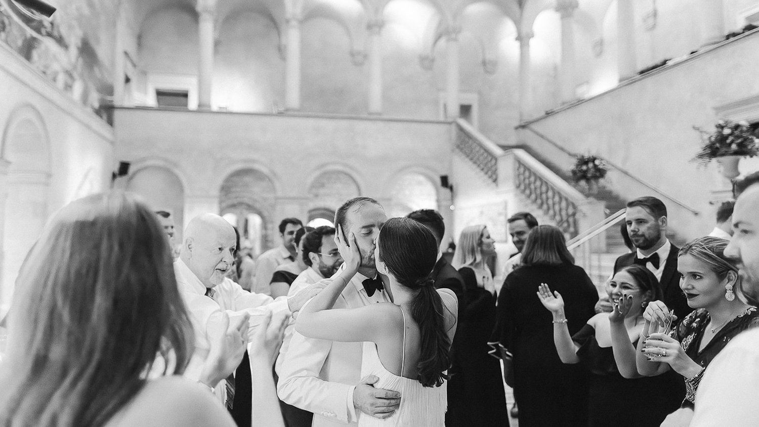 6 Tips to budget for a Boston Wedding Photographer 1 Guests applaud as couple kiss in grand stone hall