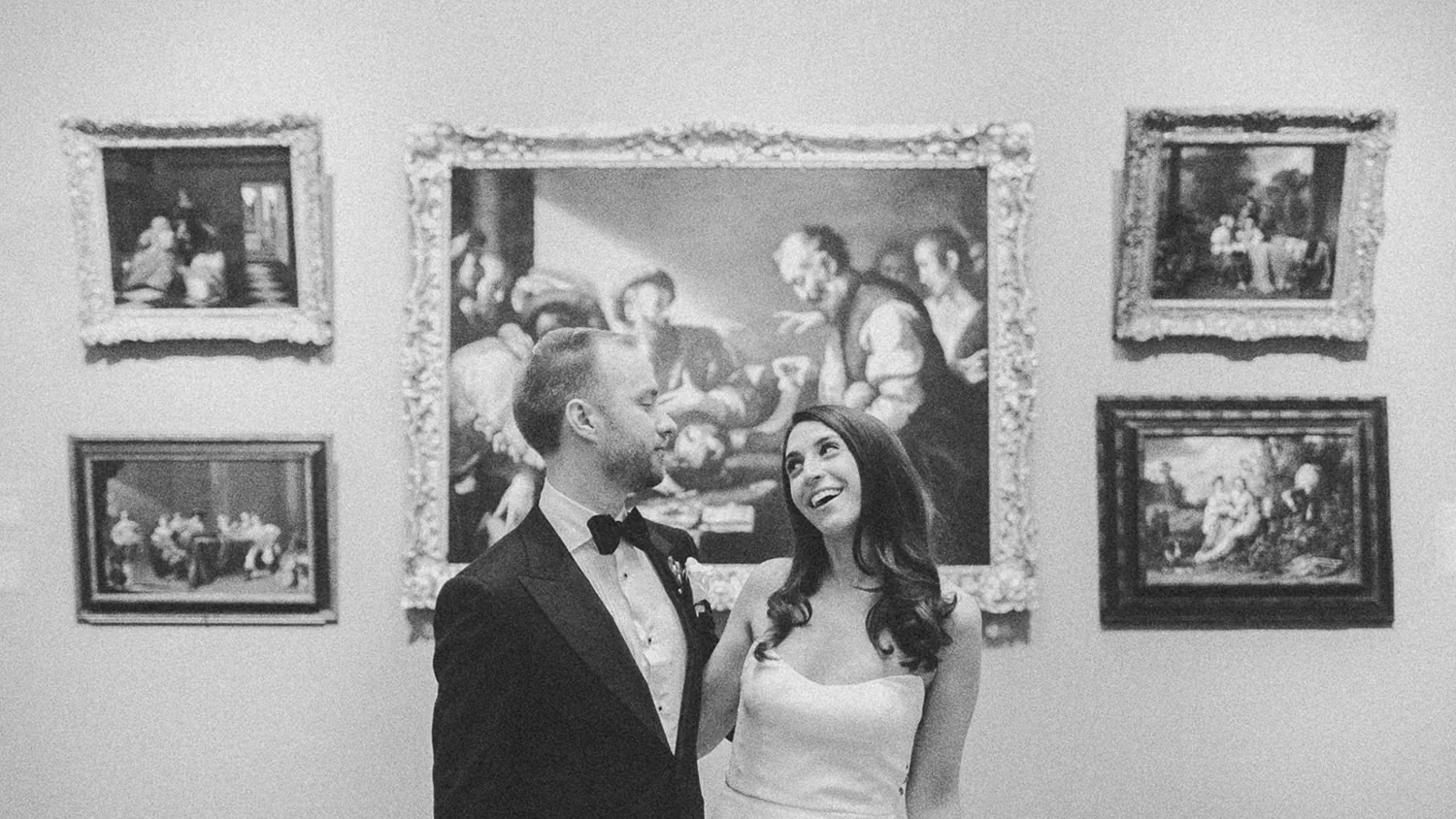 Hill-Stead Museum Wedding 1 Black and white photo of a bride and groom laughing beneath framed paintings on a gallery wall at Hill-Stead Museum in Farmington, CT