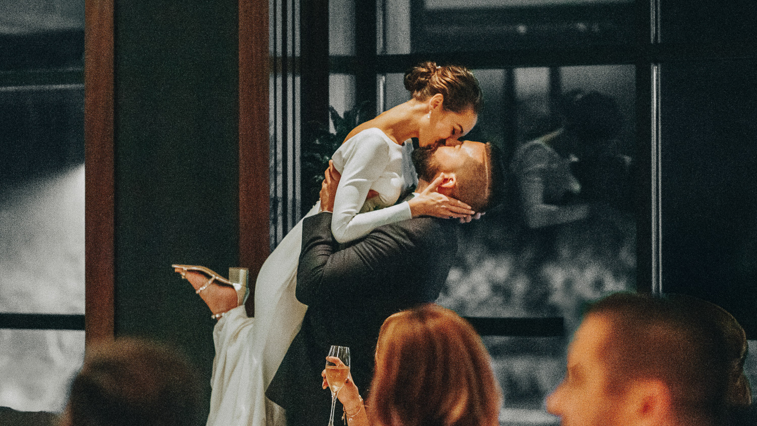 A Guide To Wedding Photographers in Boston, MA 1 Groom lifts bride mid-kiss while guests watch with champagne