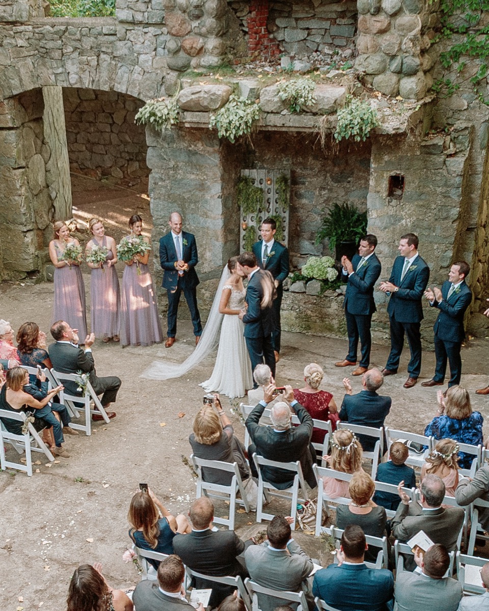 Bride and groom sharing their first kiss inside the stone castle ruins at Gibbet Hill in Groton, Massachusetts
