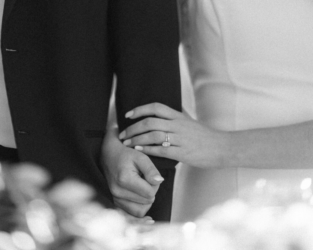 Close up of a bride and groom holding hands showing the wedding ring, detail photograph for a wedding album