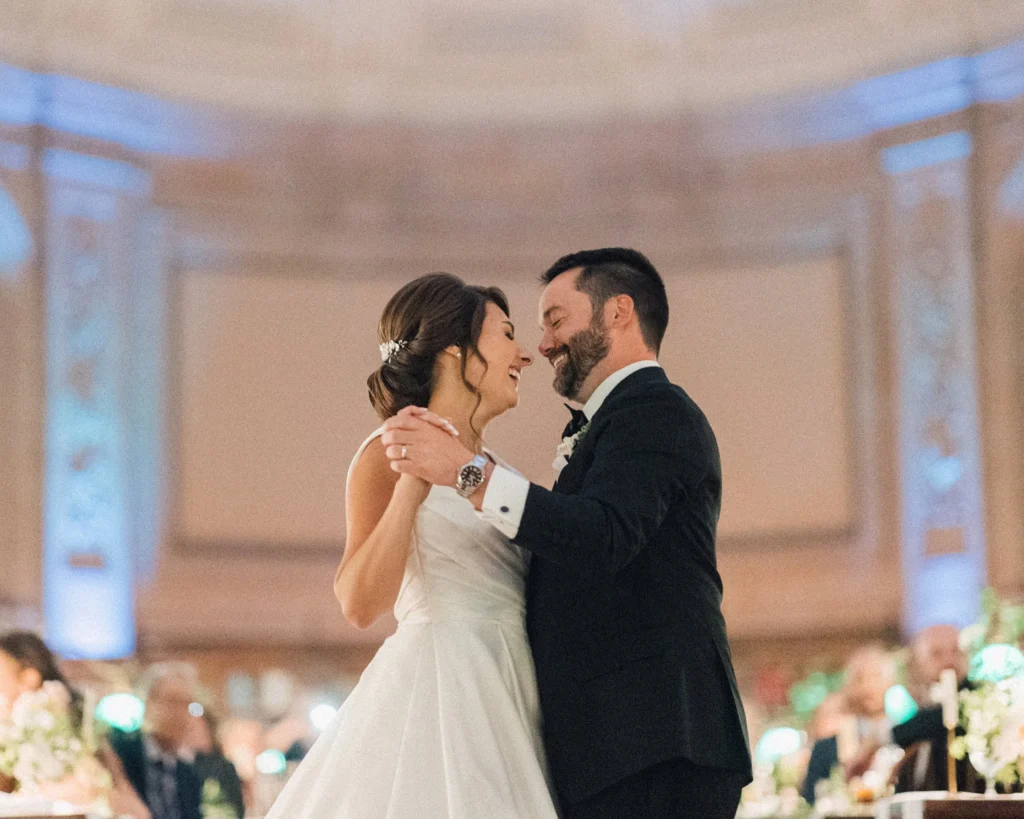 Bride and groom share their first dance beneath the murals of the Boston Public Library