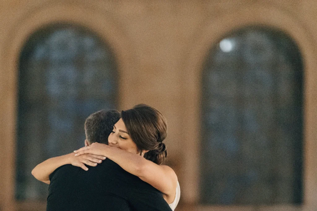 Bride hugs a guest on the dance floor at the Boston Public Library