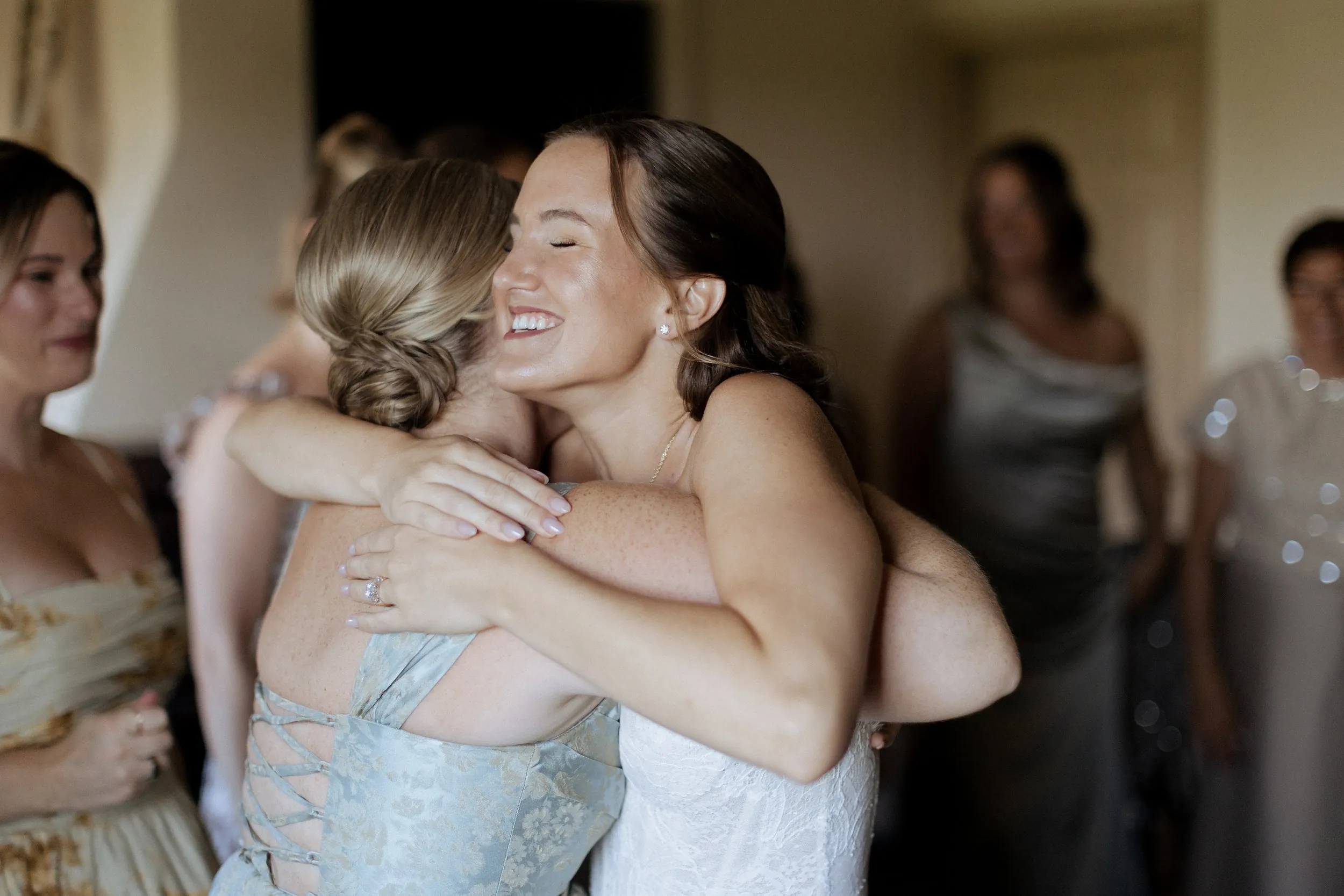 Bride hugging a bridesmaid on the morning of her Crane Estate wedding