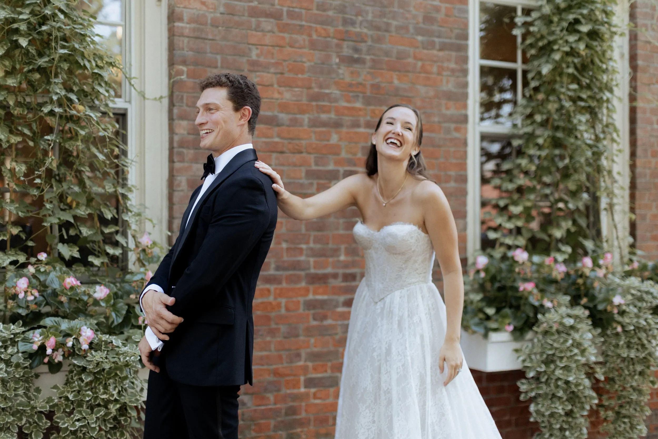 Bride and groom laughing together during their first look in Newburyport