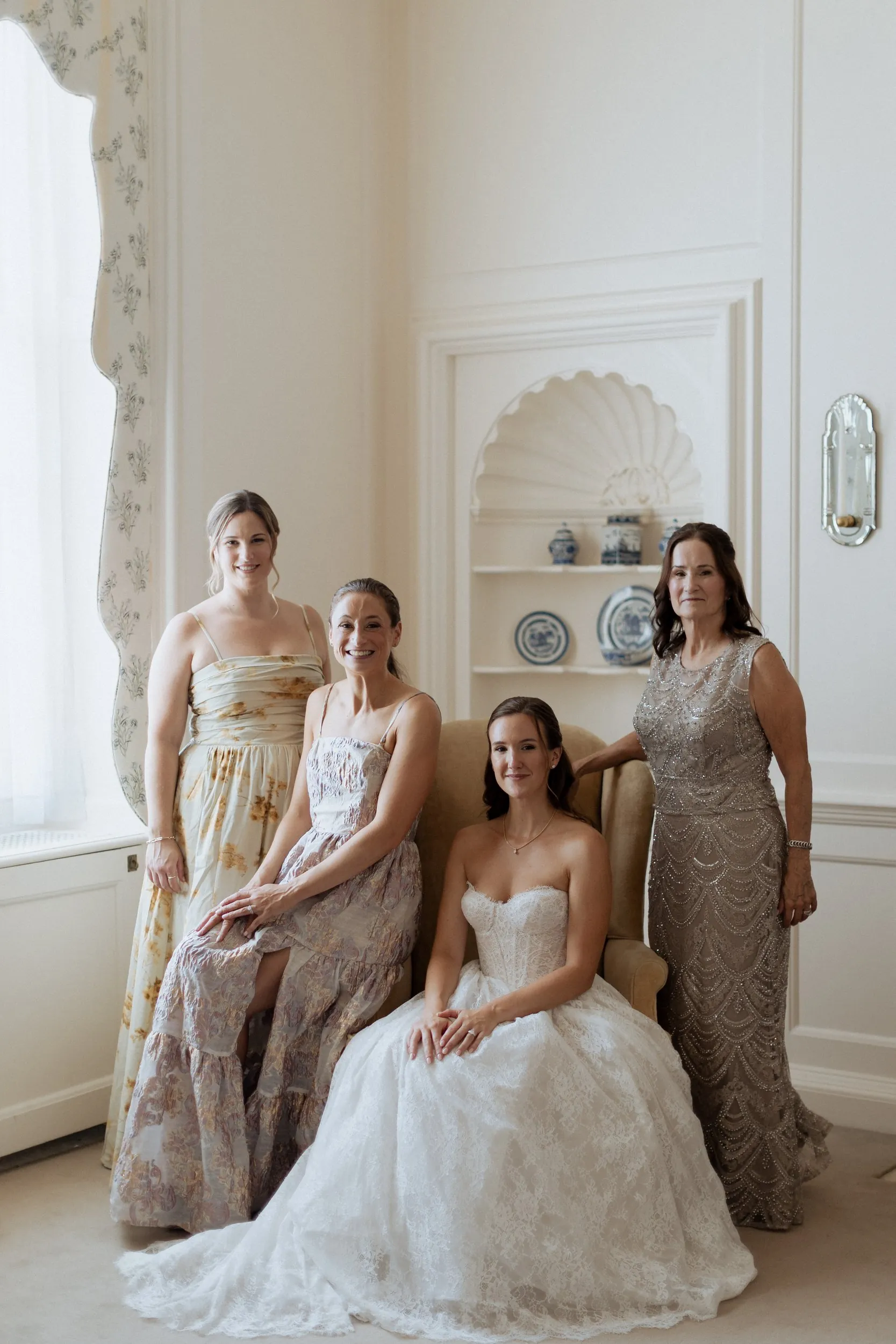 Bride seated with her mother and sisters in a room at the Great House, Crane Estate