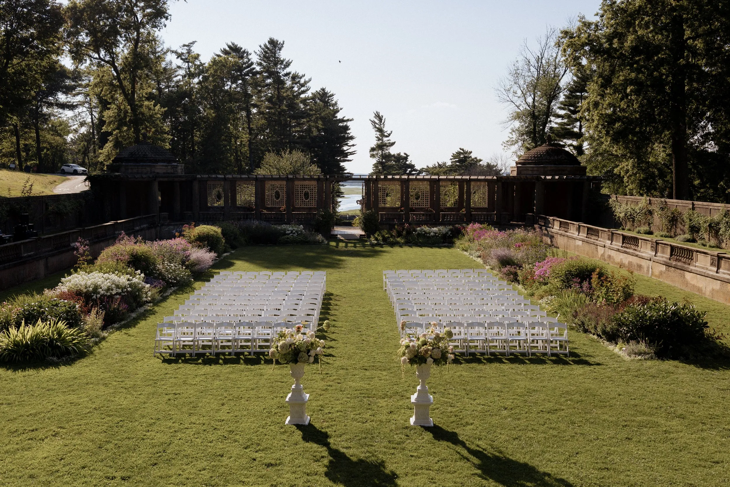 Italian Garden at Castle Hill set for a wedding ceremony with white chairs and the pergola