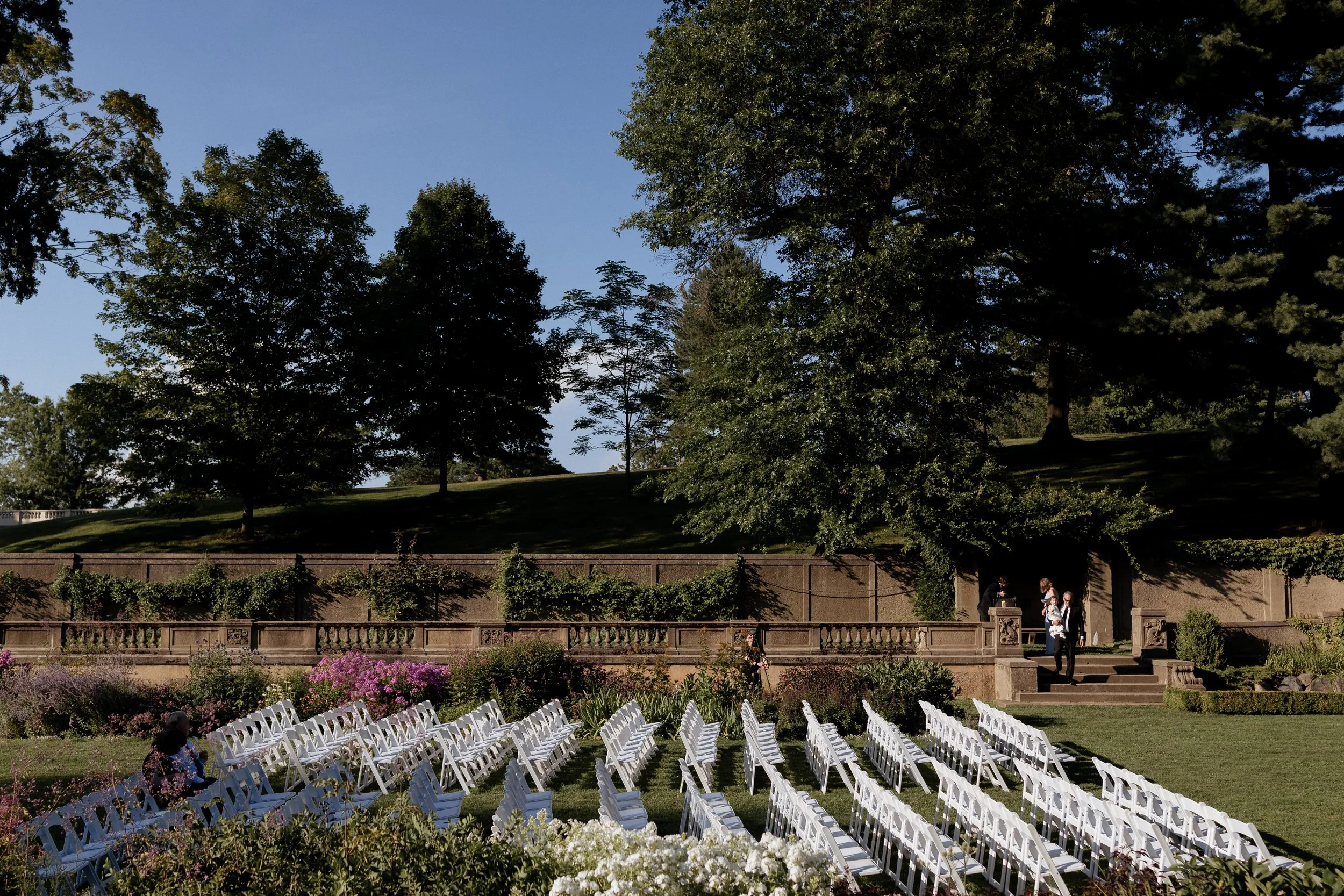 Rows of white ceremony chairs in the sunken Italian Garden at the Crane Estate