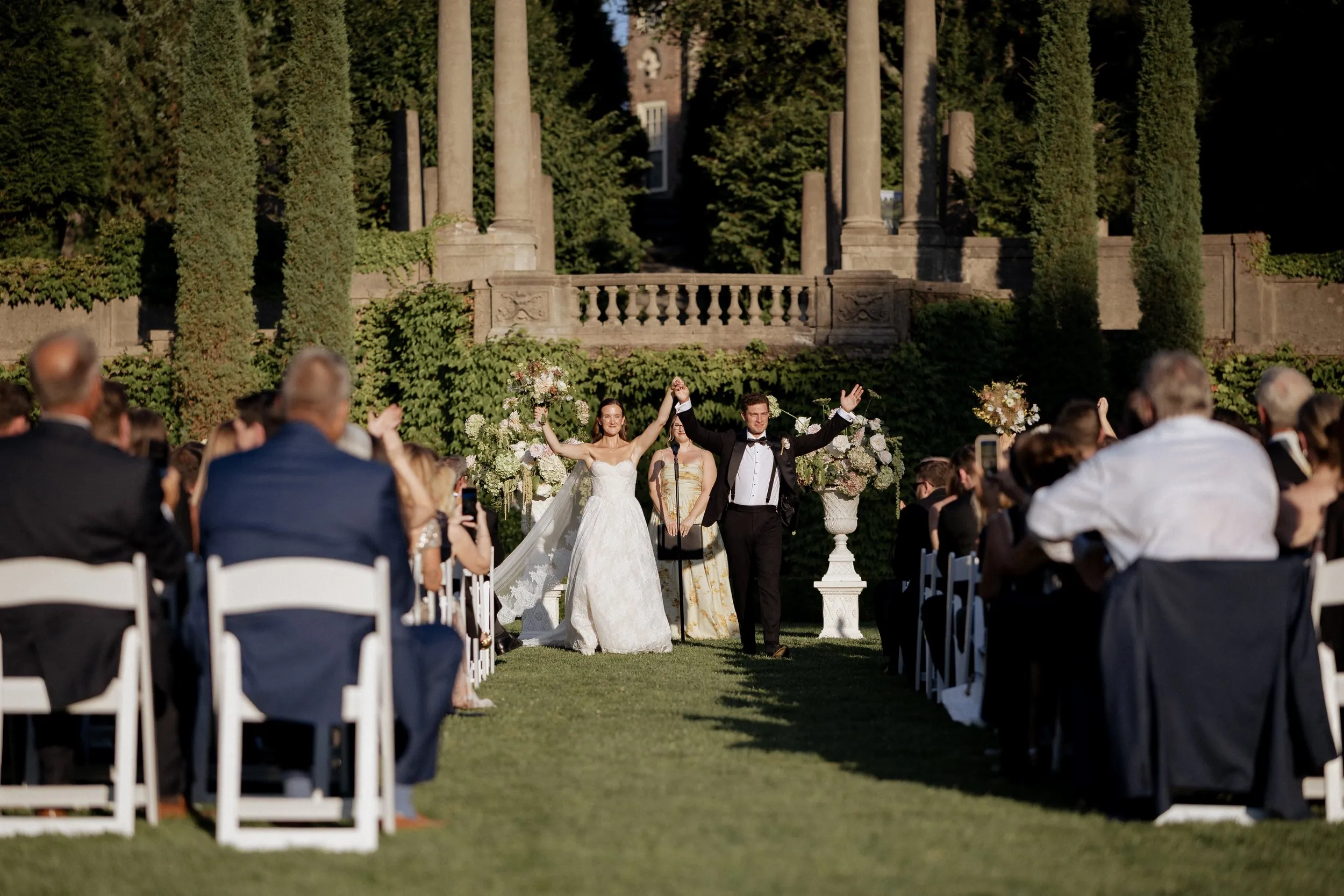 Newlyweds cheering as they walk back up the aisle past their guests