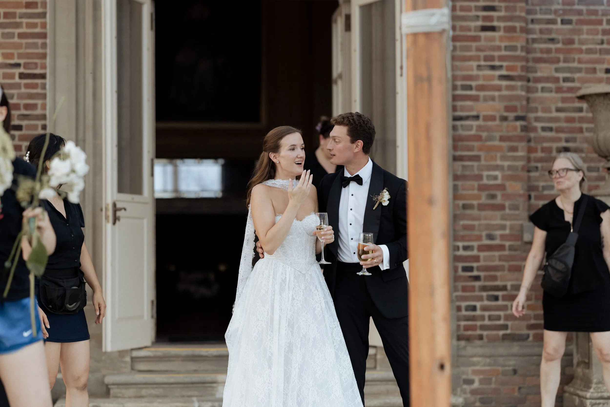 Bride and groom stepping out of the Great House with drinks at cocktail hour