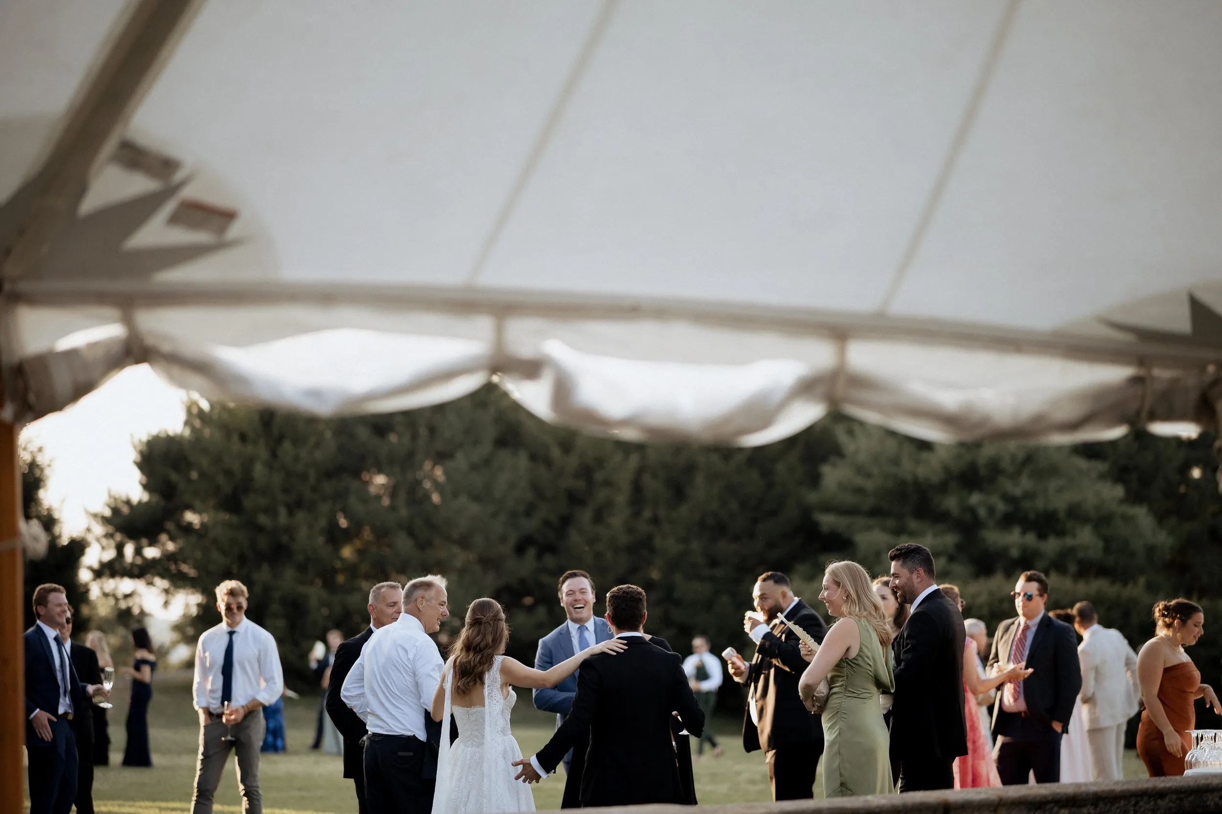 Guests on the lawn at cocktail hour with the Great House in the evening light
