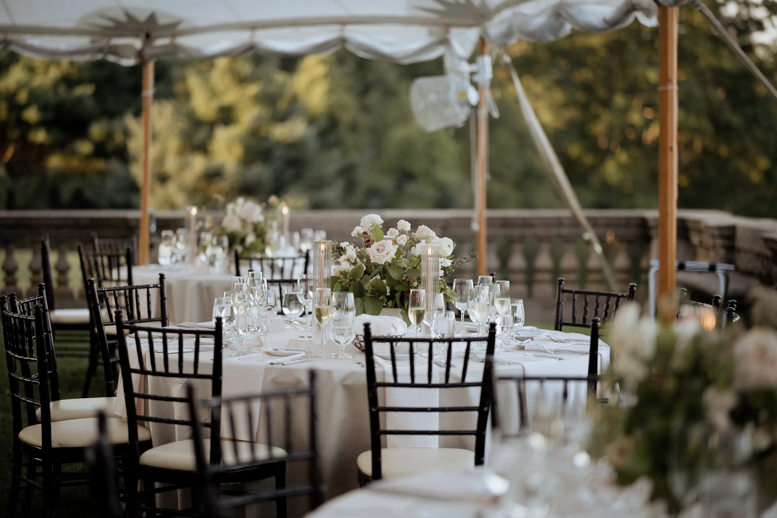 Round tables and black chiavari chairs under the tent at Castle Hill