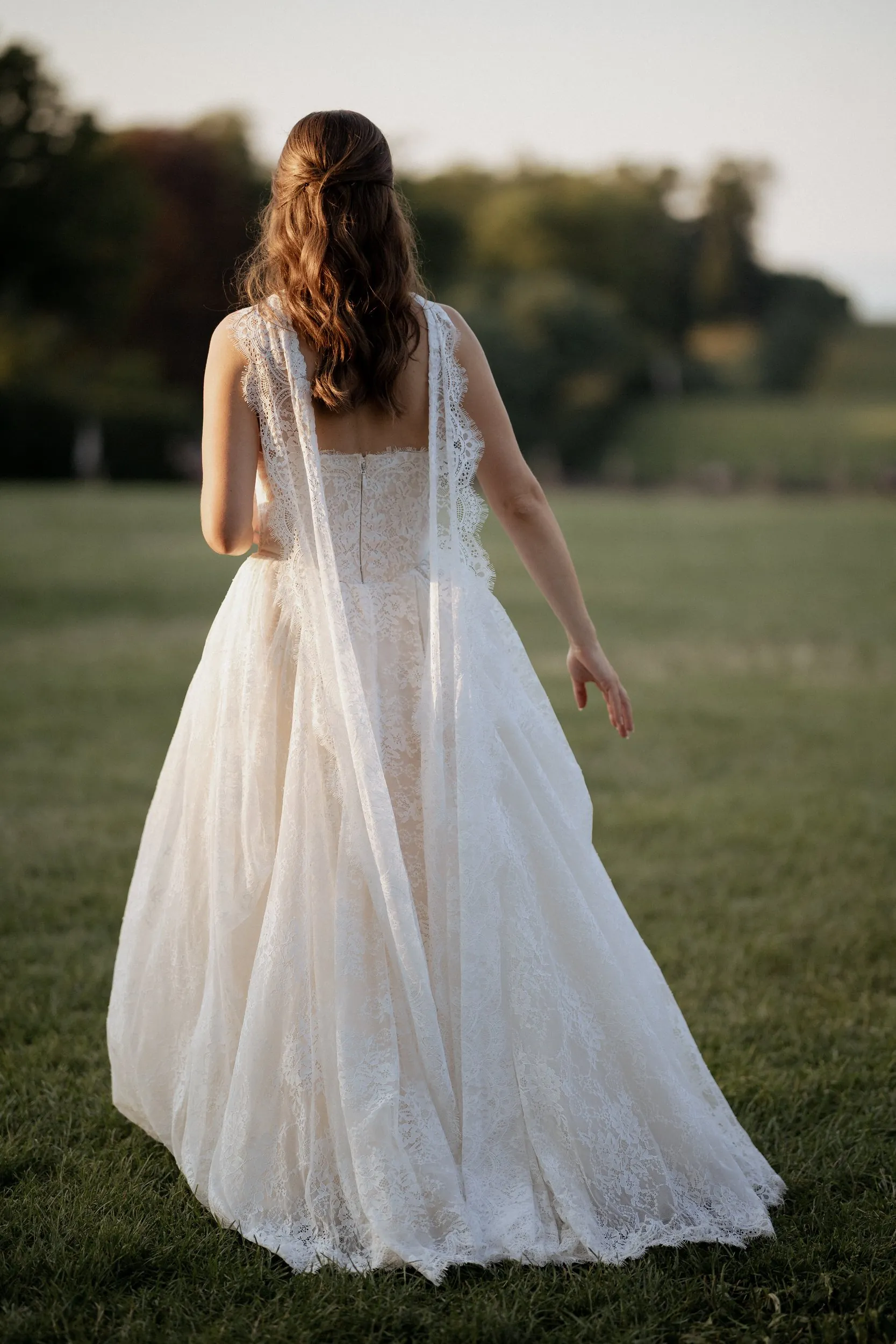 Bride from behind on the lawn at the Crane Estate at golden hour