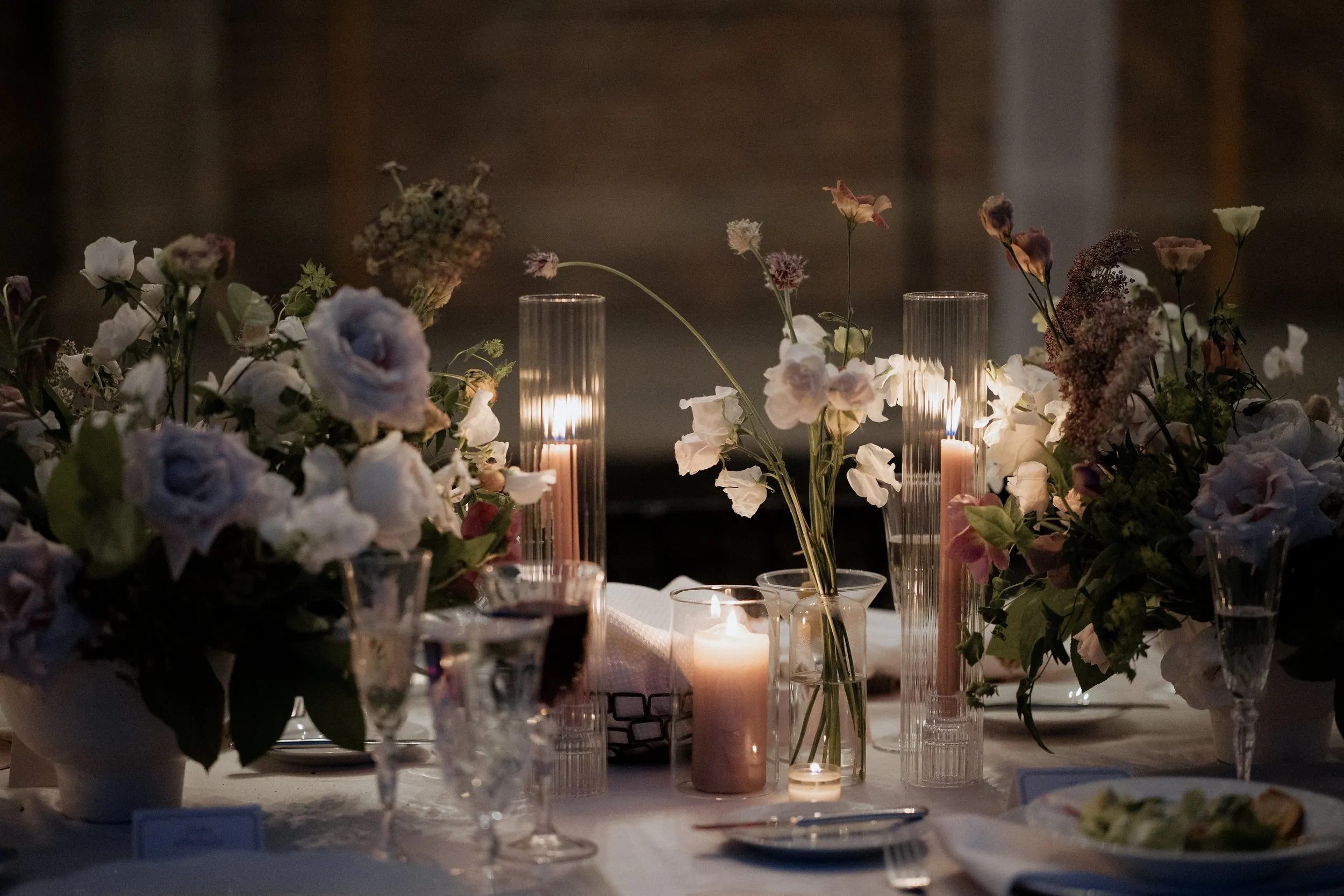 Candlelit centerpiece of roses and wildflowers at a Crane Estate wedding