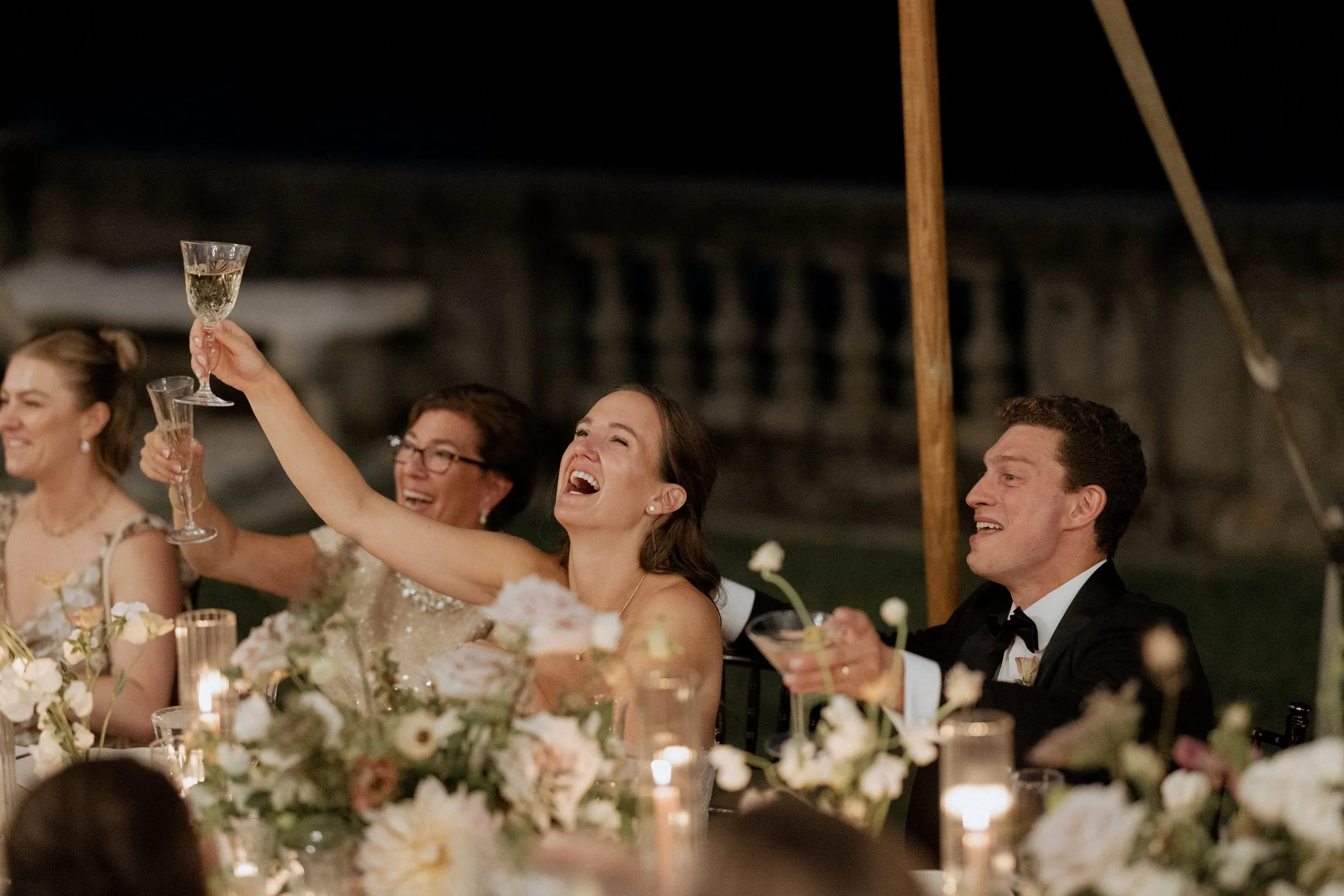 Bride and groom raising their glasses at the head table during a speech