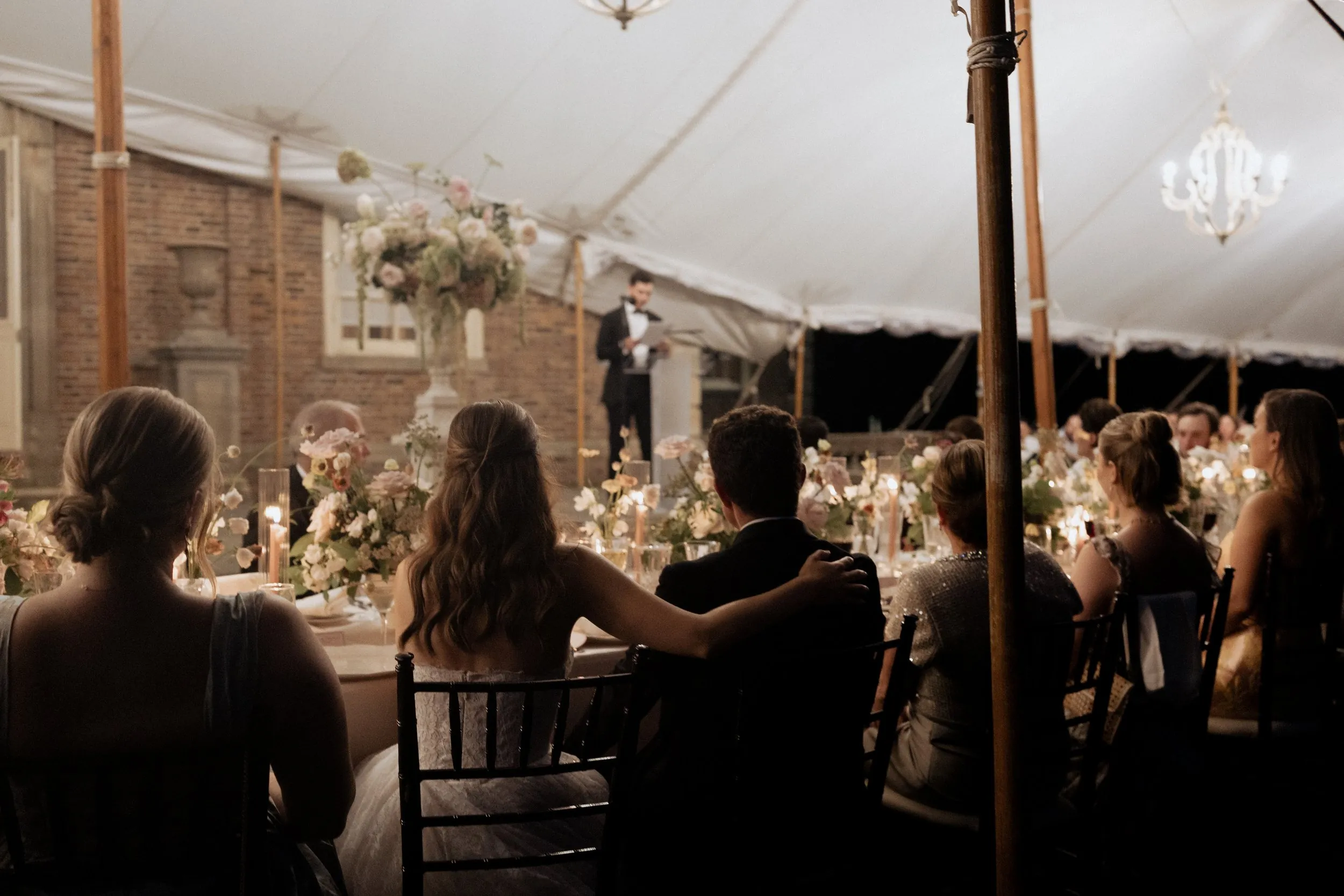The tent at night with guests listening to the speeches
