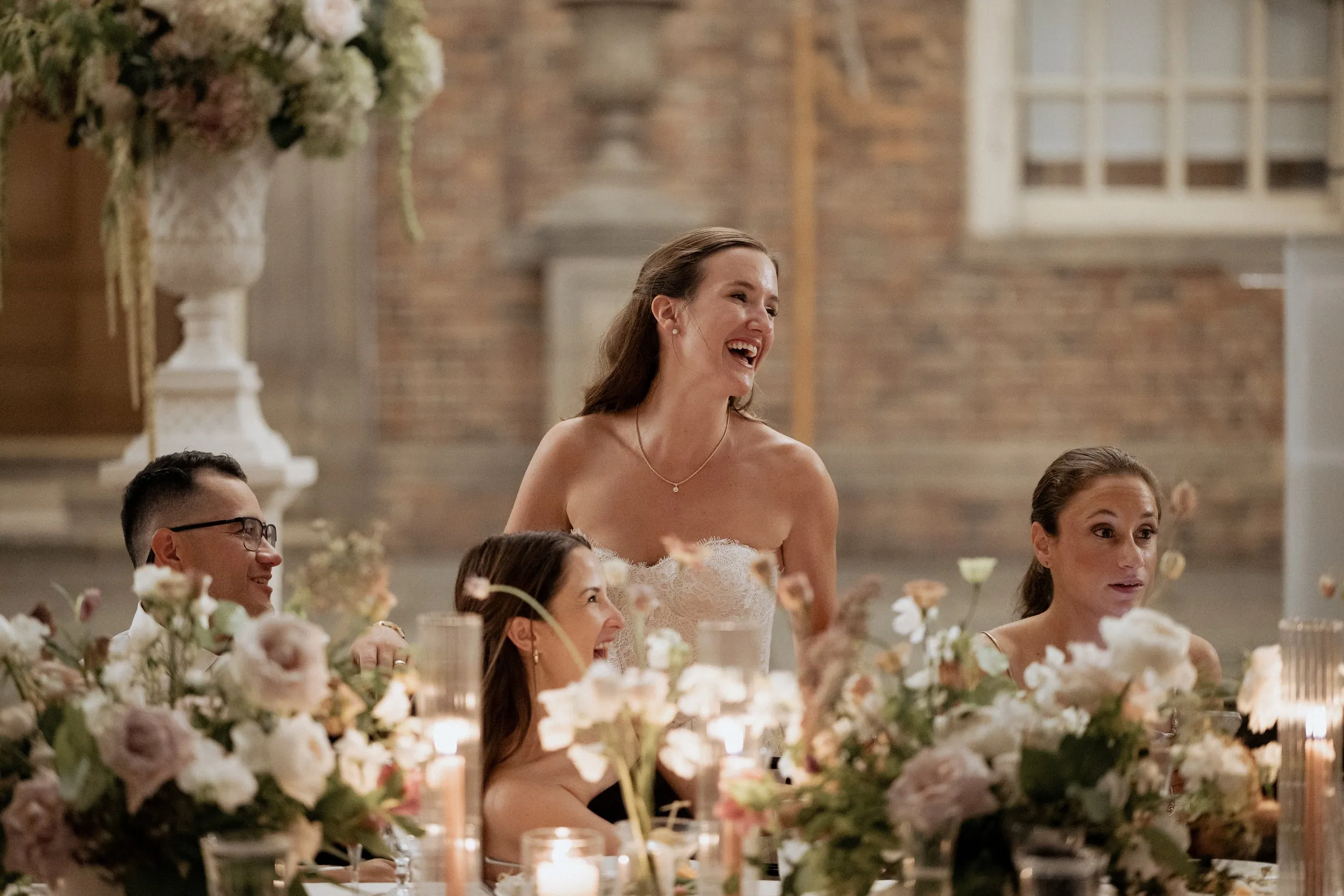 Bride standing to applaud at the end of a speech under the tent