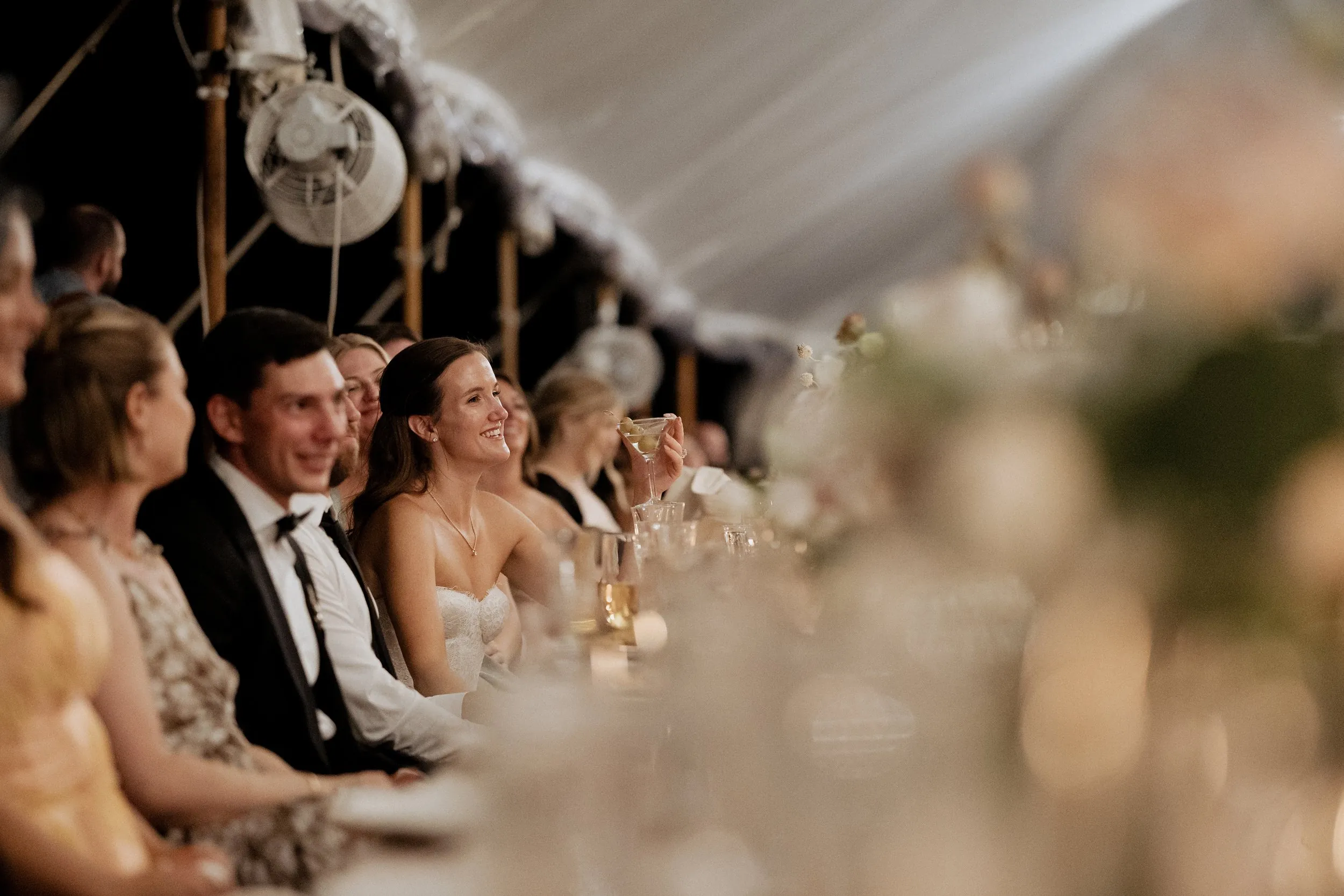 Bride listening to the groom's speech at the head table
