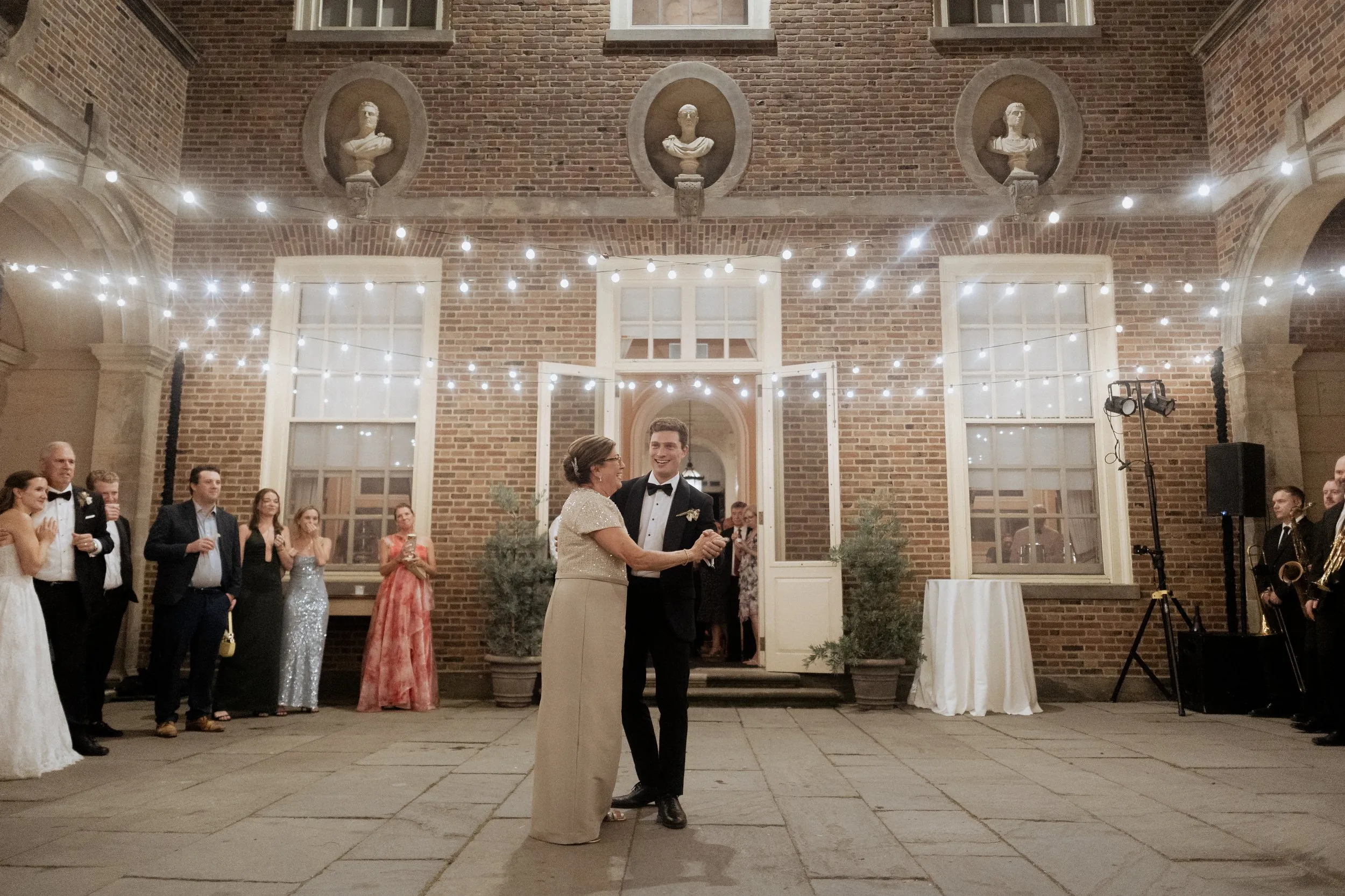 Mother-son dance in the Great House courtyard with guests around the edge