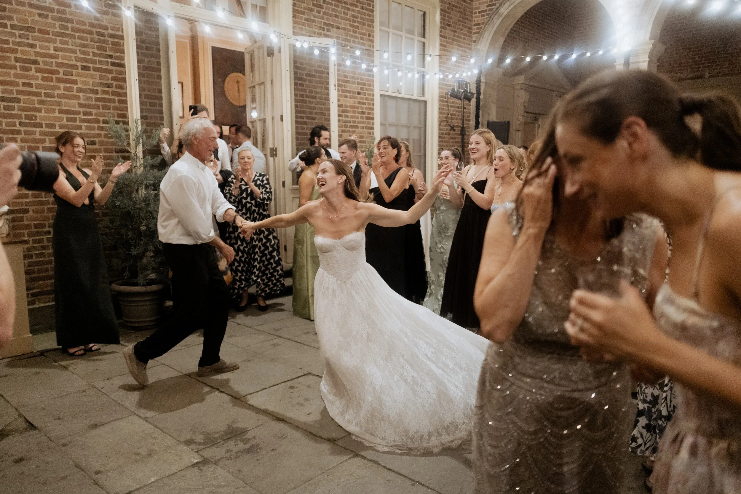 Bride dancing with her father as the courtyard party goes on