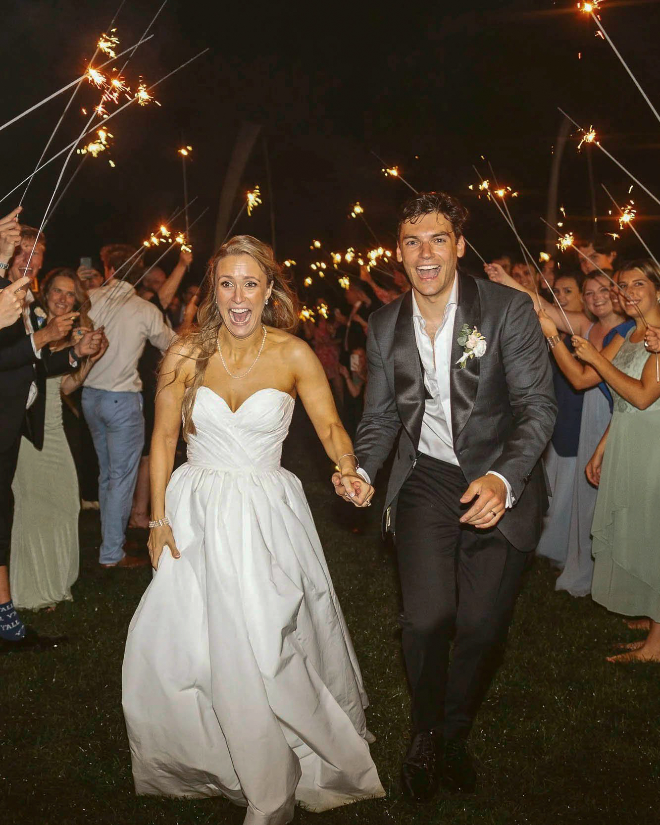 A couple runs through a sparkler exit at a Duxbury wedding