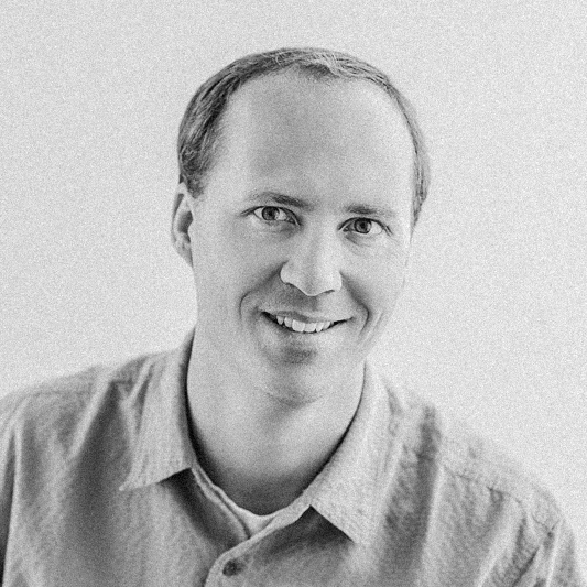 Eric, team lead wedding photographer for New England, smiling in a black and white headshot