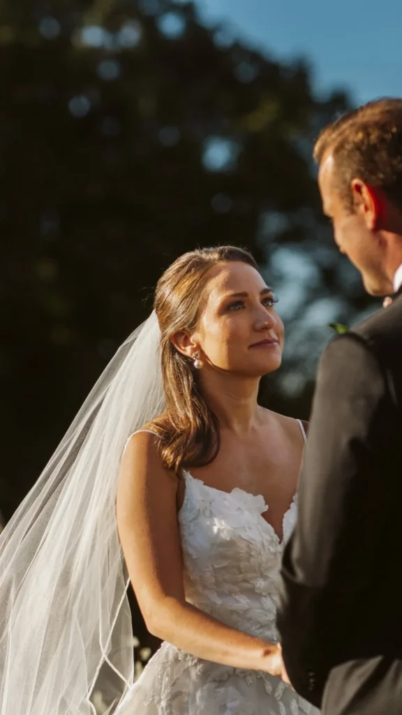 Close vertical frame of the bride in her veil looking up at the groom at the altar at Hill-Stead Museum