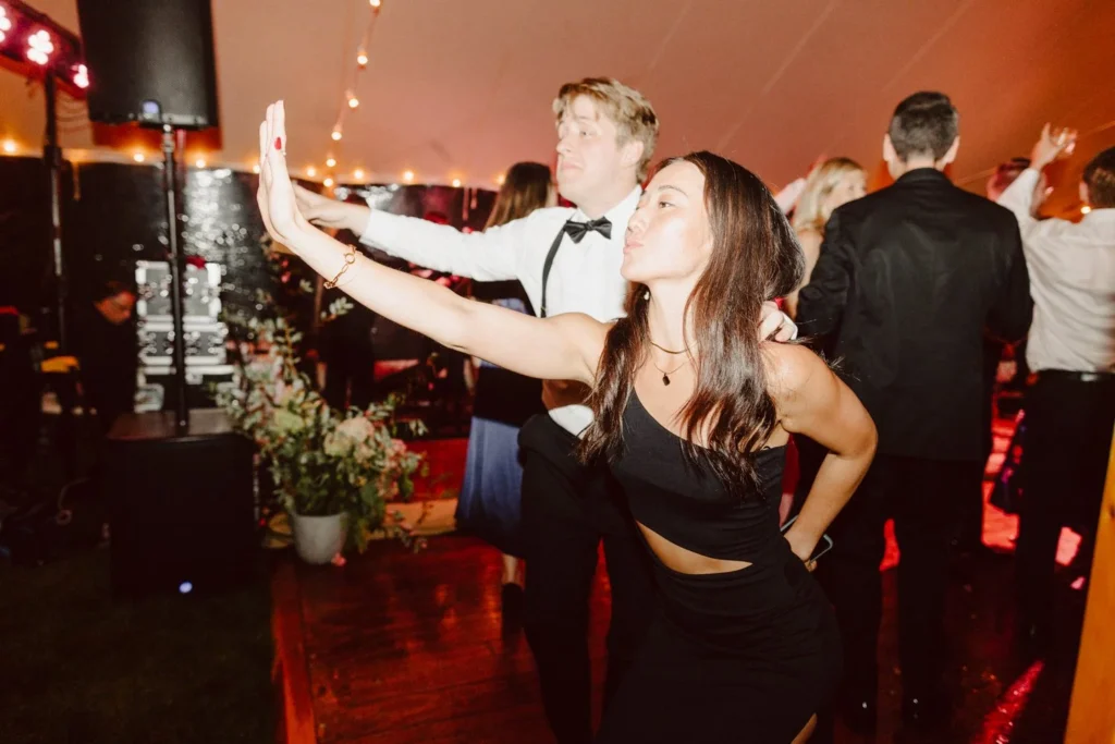 Wedding guests dance under the tent at Hill-Stead Museum with the band lights behind them