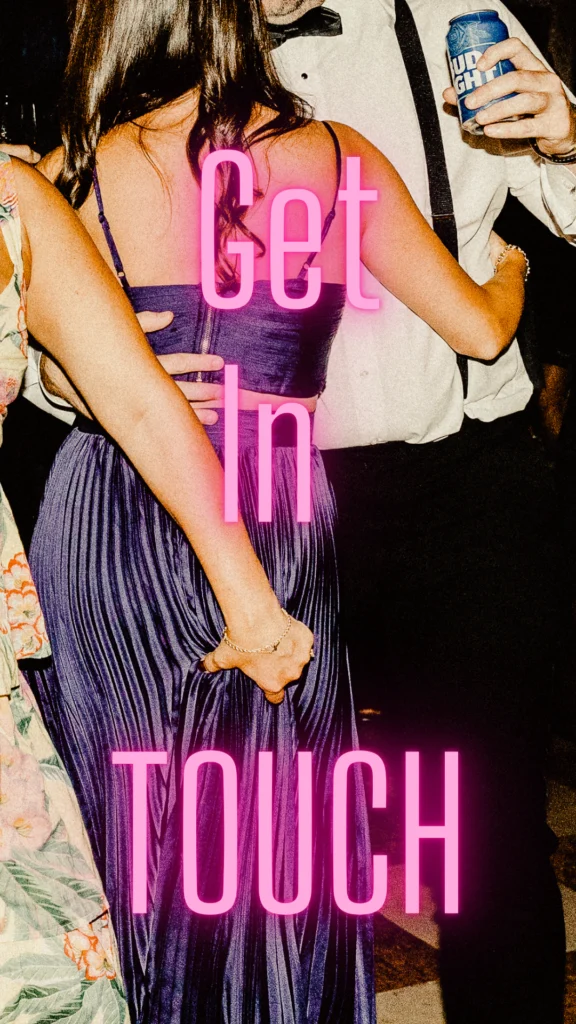 A pink neon Get In Touch sign glows over dancing guests late at night at a Hill-Stead Museum wedding