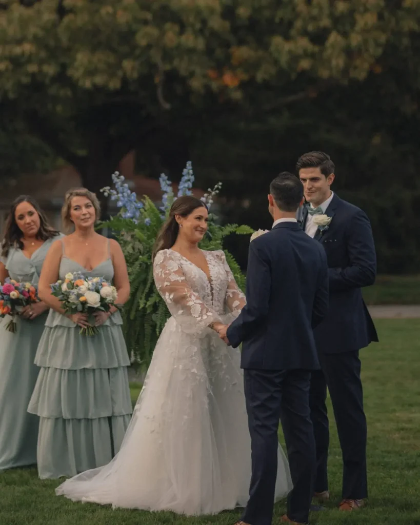 Bride and bridesmaids in sage dresses during a lawn ceremony at Tupper Manor