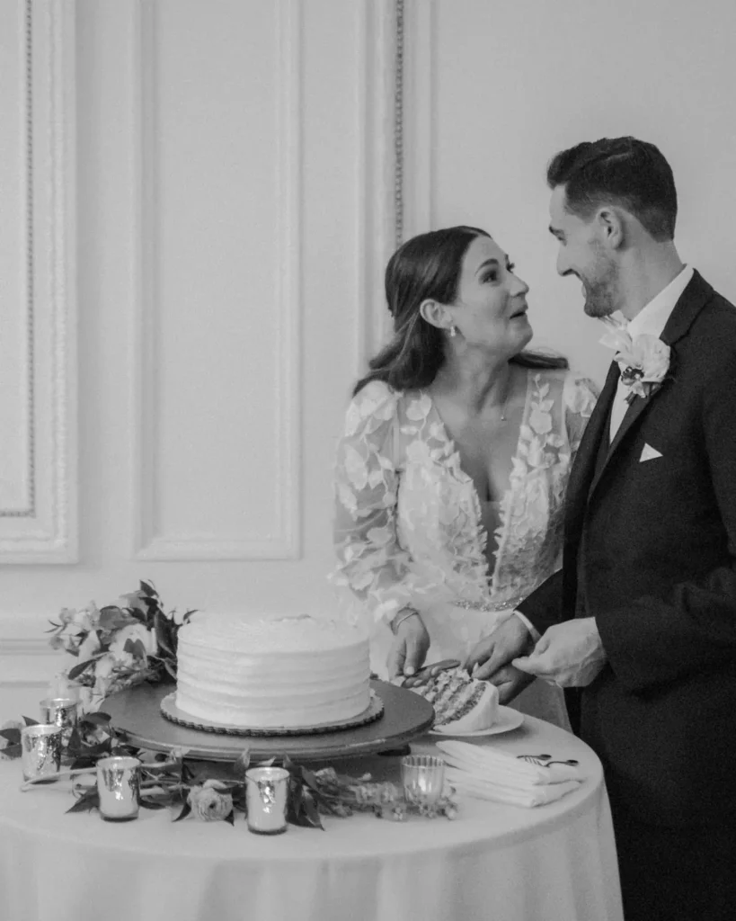 Bride and groom cut their wedding cake at Tupper Manor in black and white