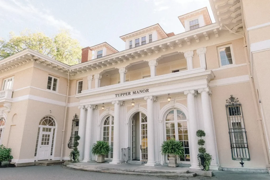 White columns and arched windows at the front entrance of Tupper Manor in daylight