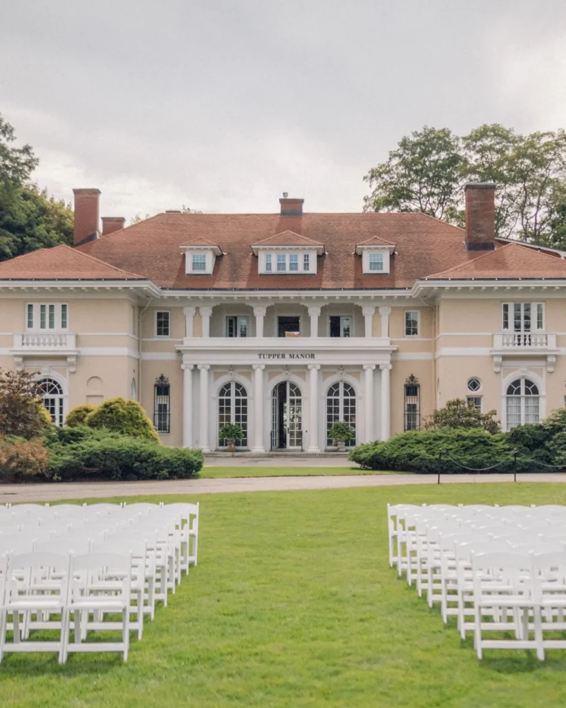 Tupper Manor with rows of white ceremony chairs set on the front lawn before a wedding